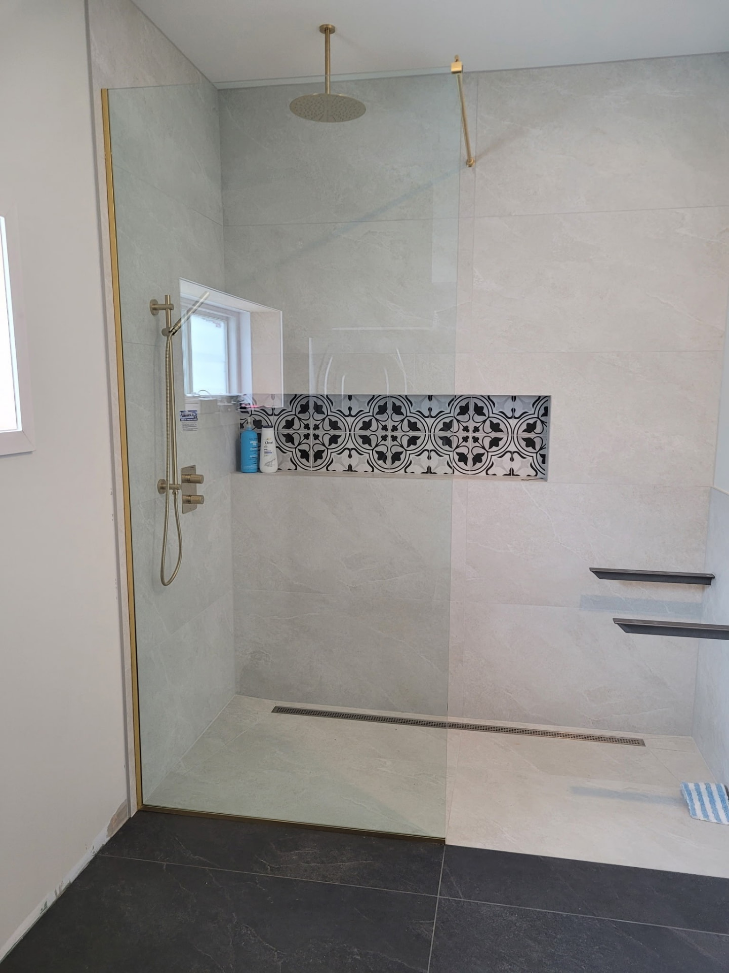 Douche ouverte avec panneau fixe en verre clair et quincaillerie dorée