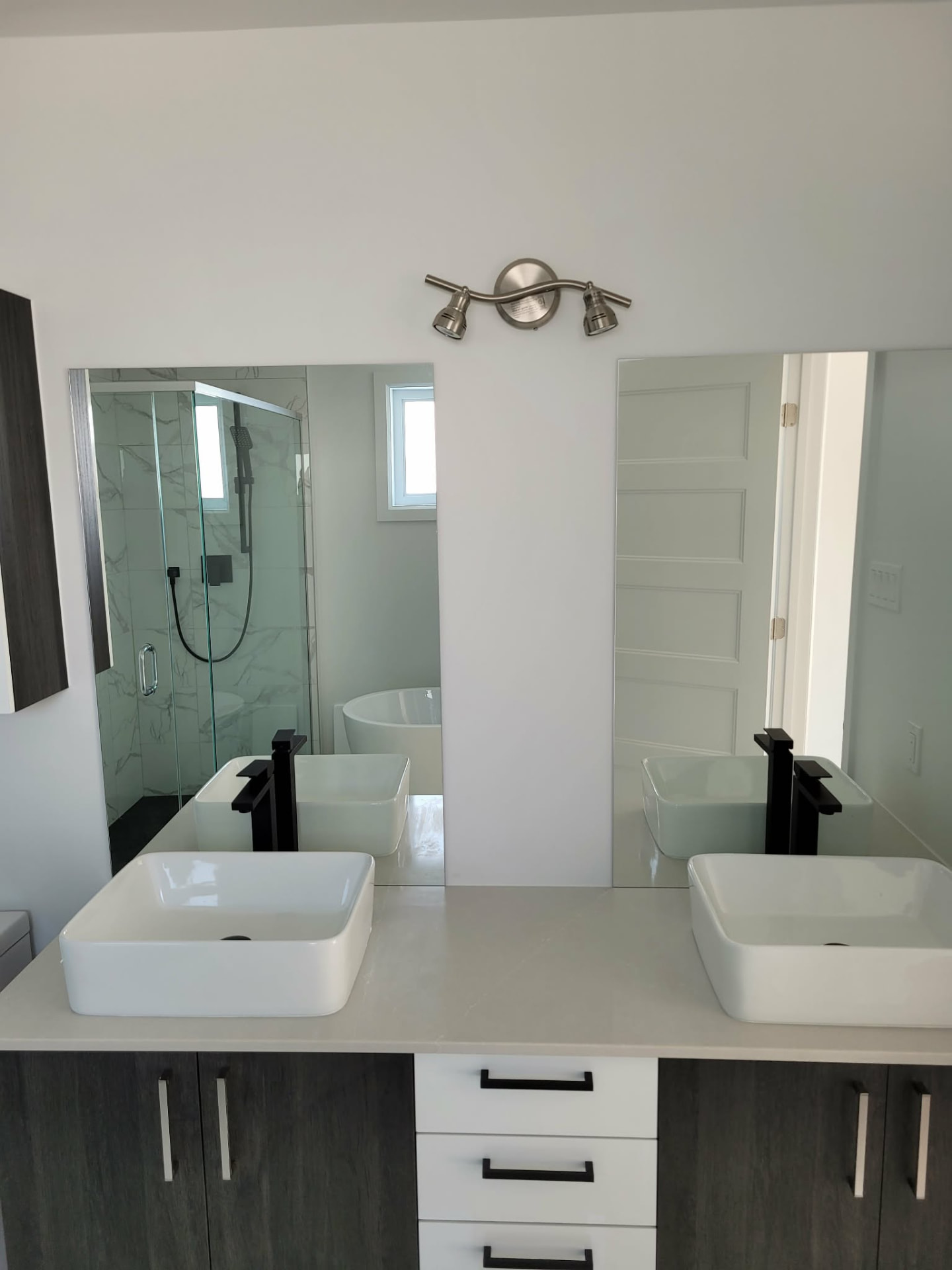 Deux miroirs rectangulaires installés au-dessus d'une vanité de salle de bain