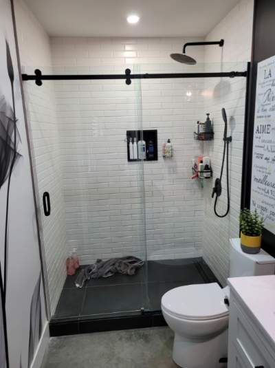 Douche vitrée avec porte coulissante sur rail noir