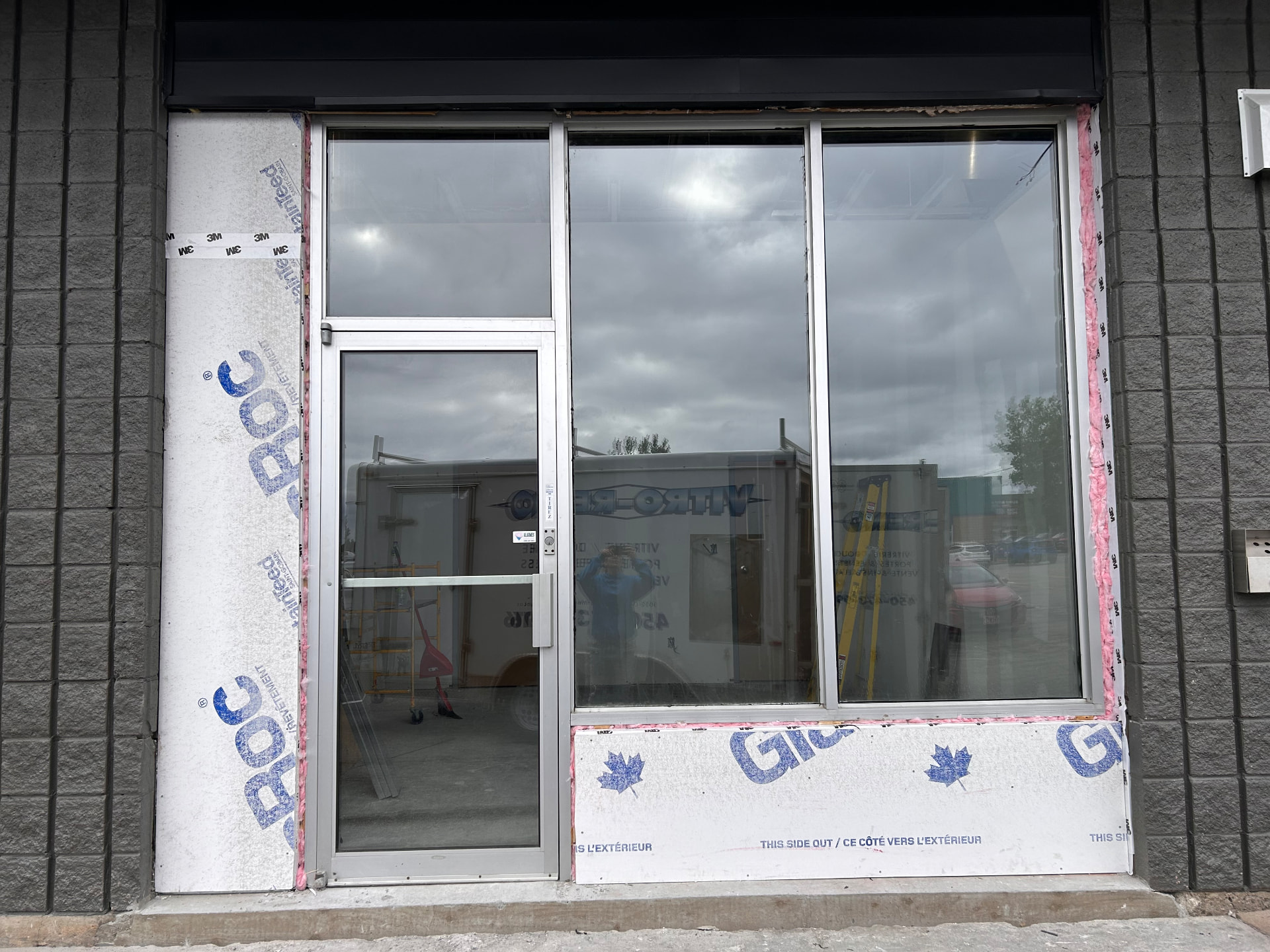Porte commerciale vitrée intégrée à une façade en verre