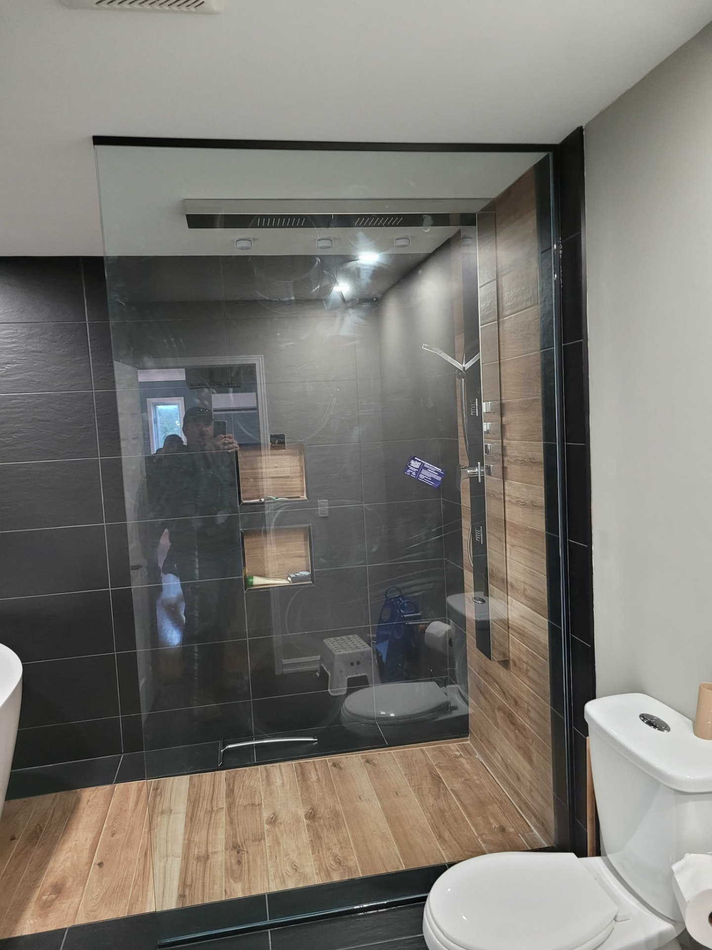 Douche vitrée avec encadrement noir dans une salle de bain contemporaine